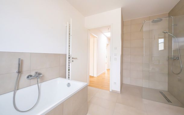 Badezimmer mit Badewanne und begehbarer Dusche in neuem Stadthaus in Viechtach